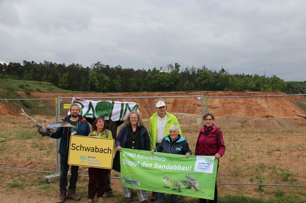 von links BN-Regionalreferent Jonas Kaufmann mit einem Modell der Blauflügeligen Ödlandschrecke, hinten Wolfgang Dötsch (BN-Projekt SandAchse) mit Aktiven der BN-Kreisgruppen Schwabach und Nürnberg-Stadt (Foto: BN) von links BN-Regionalreferent Jonas Kaufmann mit einem Modell der Blauflügeligen Ödlandschrecke, hinten Wolfgang Dötsch (BN-Projekt SandAchse) mit Aktiven der BN-Kreisgruppen Schwabach und Nürnberg-Stadt